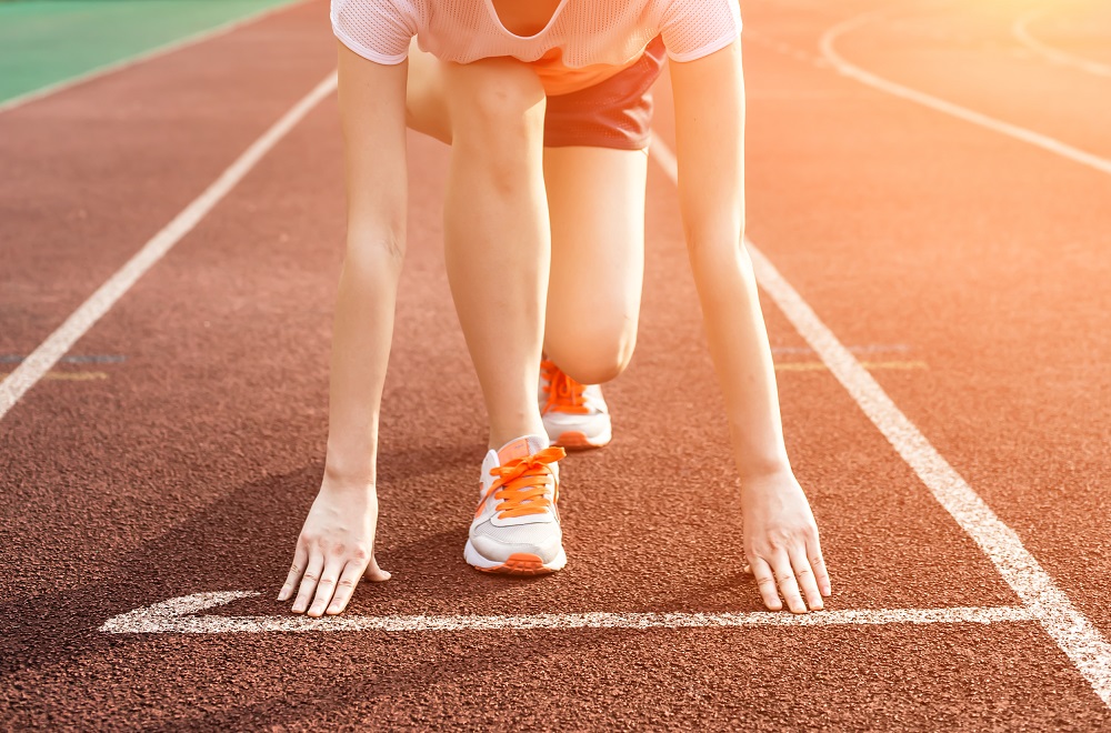 Athletic woman running on track