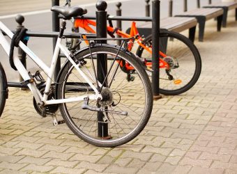 Low angle closeup shot of two bicycles parked on the sidewalk