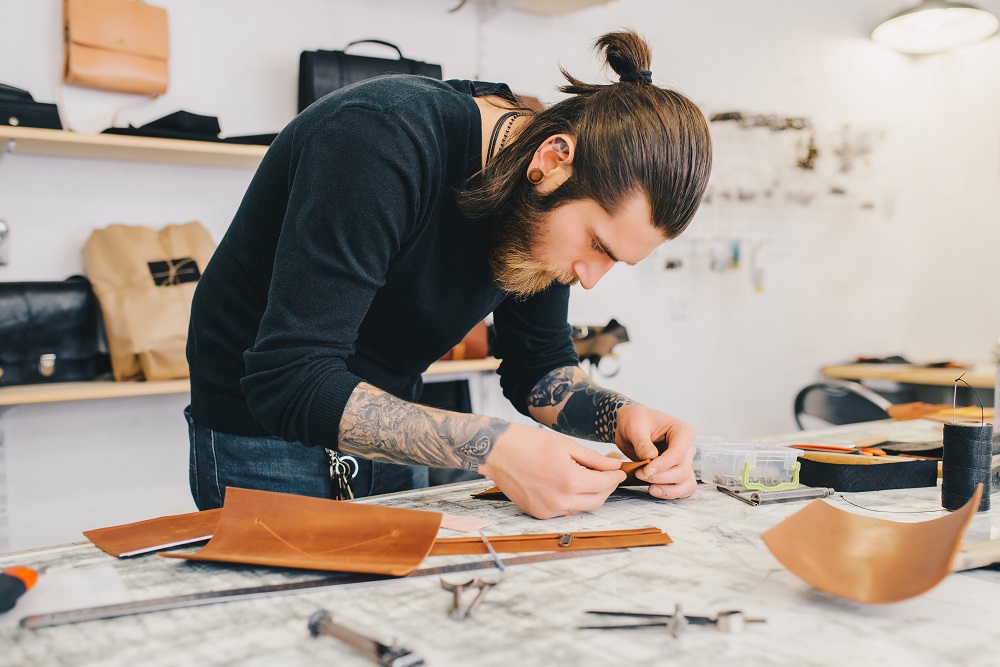 Working process of the leather bag in the leather workshop. Man