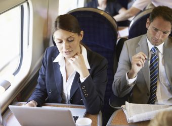 Zwei Geschäftsreisende sitzen in der Bahn.