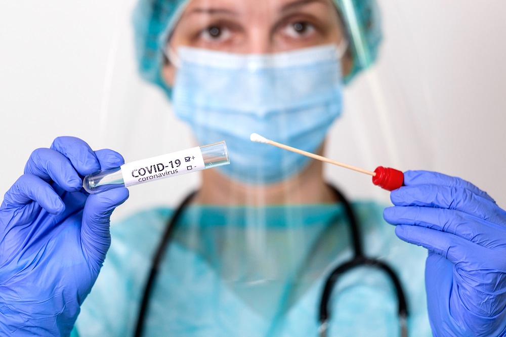 Medical healthcare holding COVID-19 , Coronavirus swab collection kit, wearing PPE protective suit mask gloves, test tube for taking OP NP patient specimen sample,PCR DNA testing protocol process