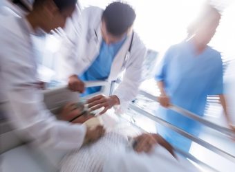 Team of doctors putting oxygen mask on a male senior patient face in the hospital