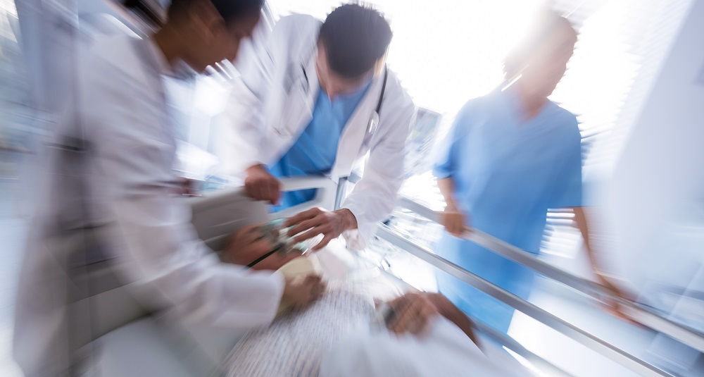 Team of doctors putting oxygen mask on a male senior patient face in the hospital