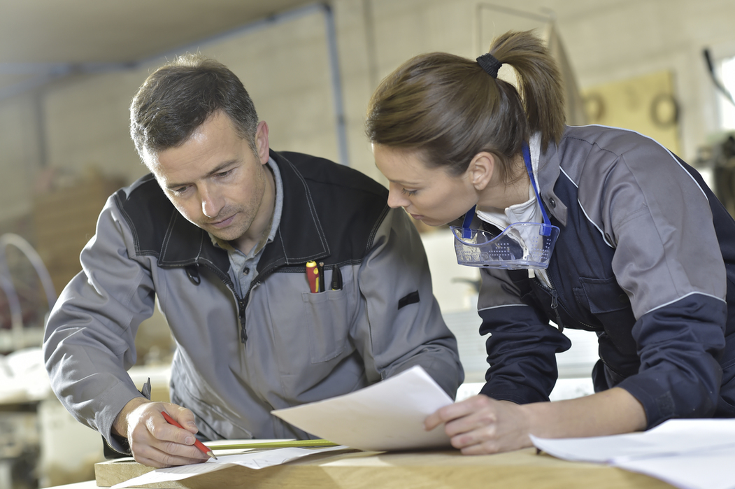 Workers measuring wood plank