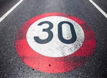 30km/h speed limit sign painted on asphalting road.