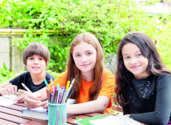 Children, boy and girl, doing homework and drawing together in g