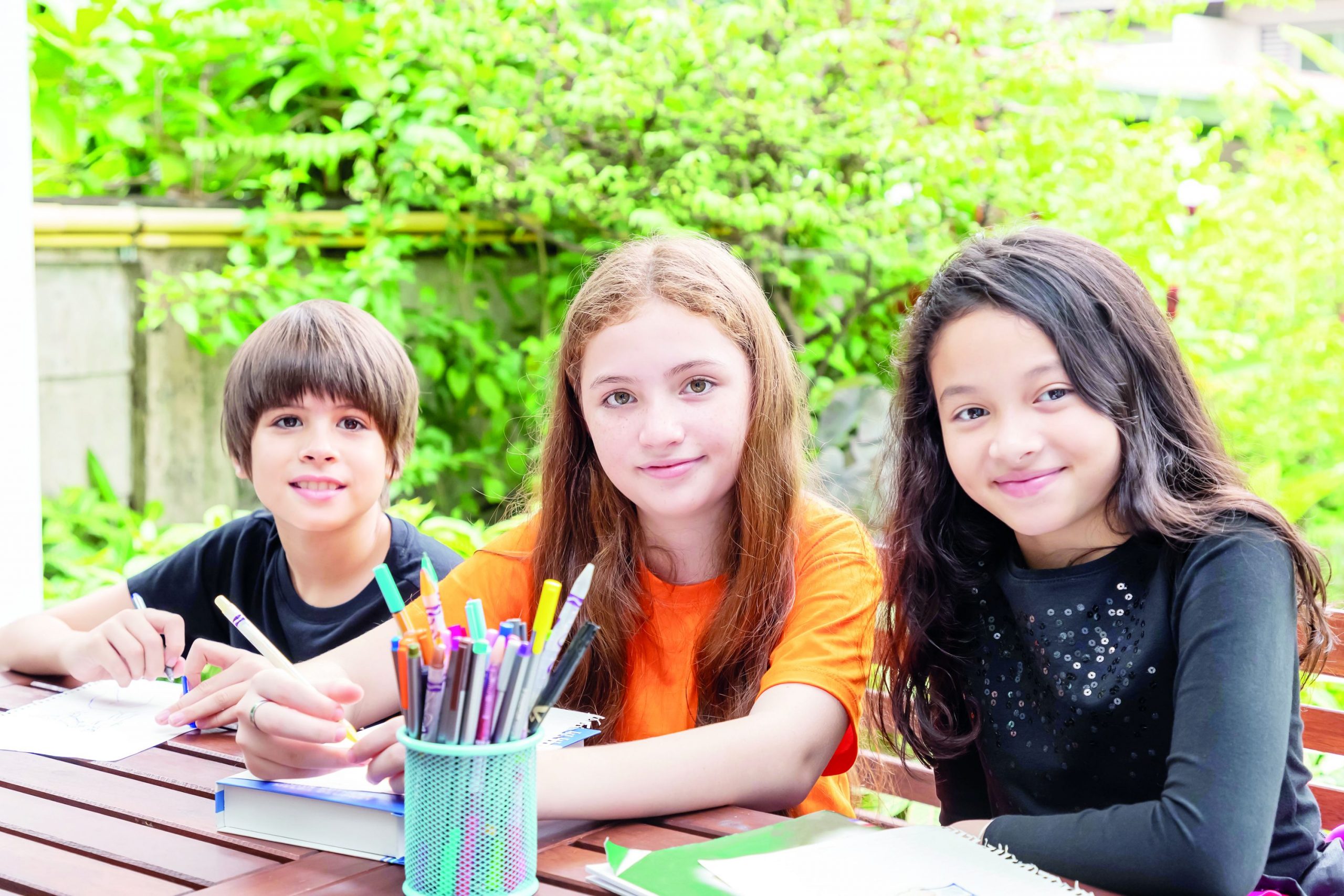 Children, boy and girl, doing homework and drawing together in g