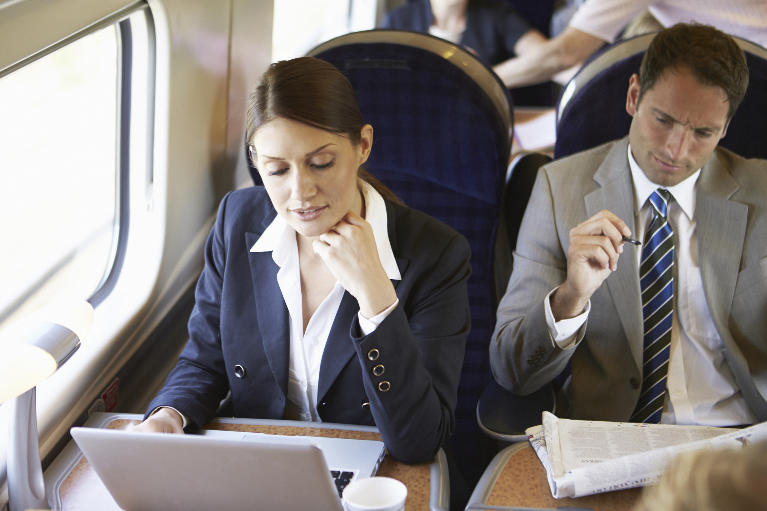 Zwei Geschäftsreisende sitzen in der Bahn.