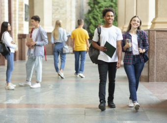 Gut gelaunte Studierende laufen auf dem Campus